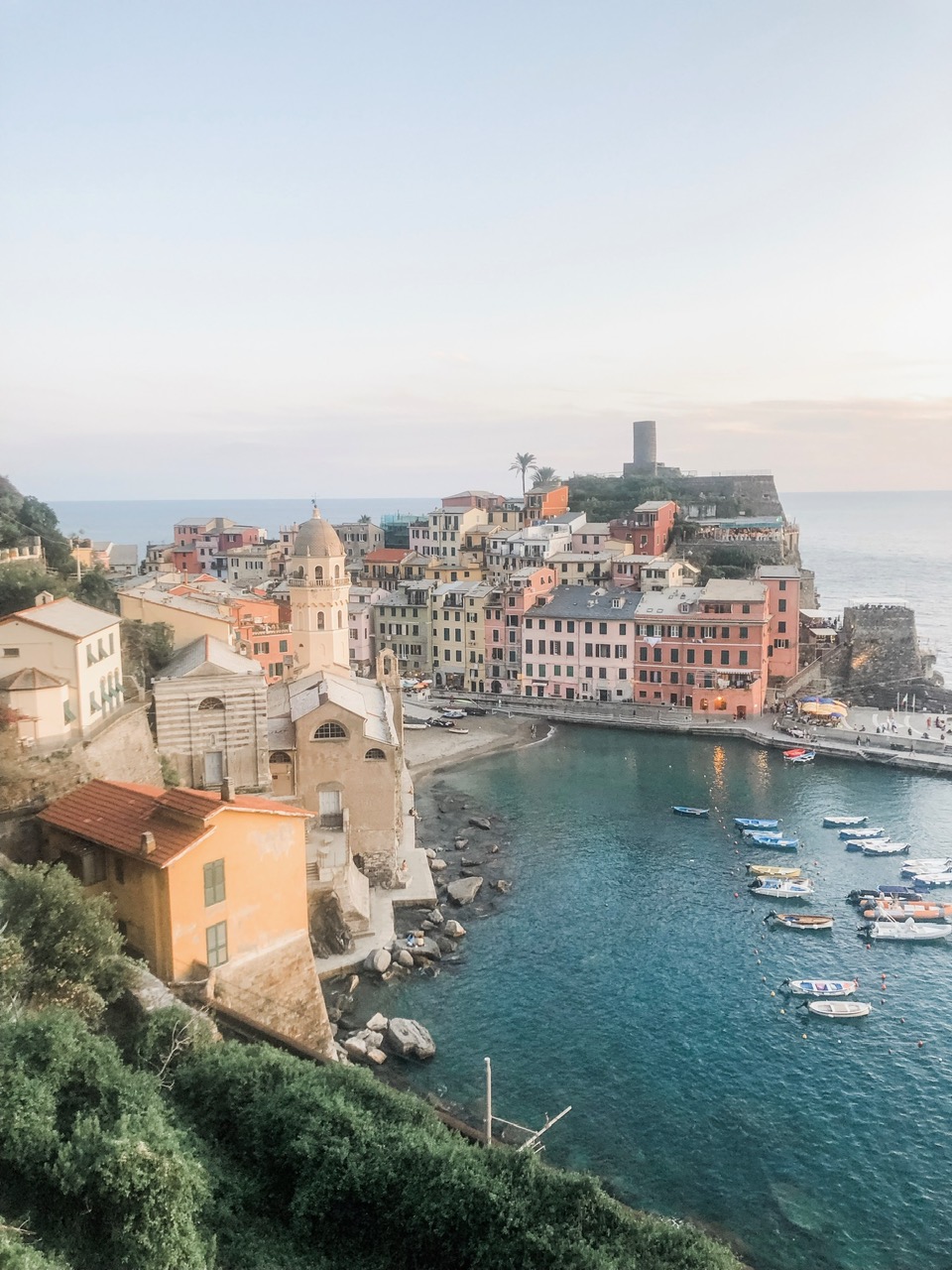 Pastel buildings and boats around Vernazza harbor at dusk